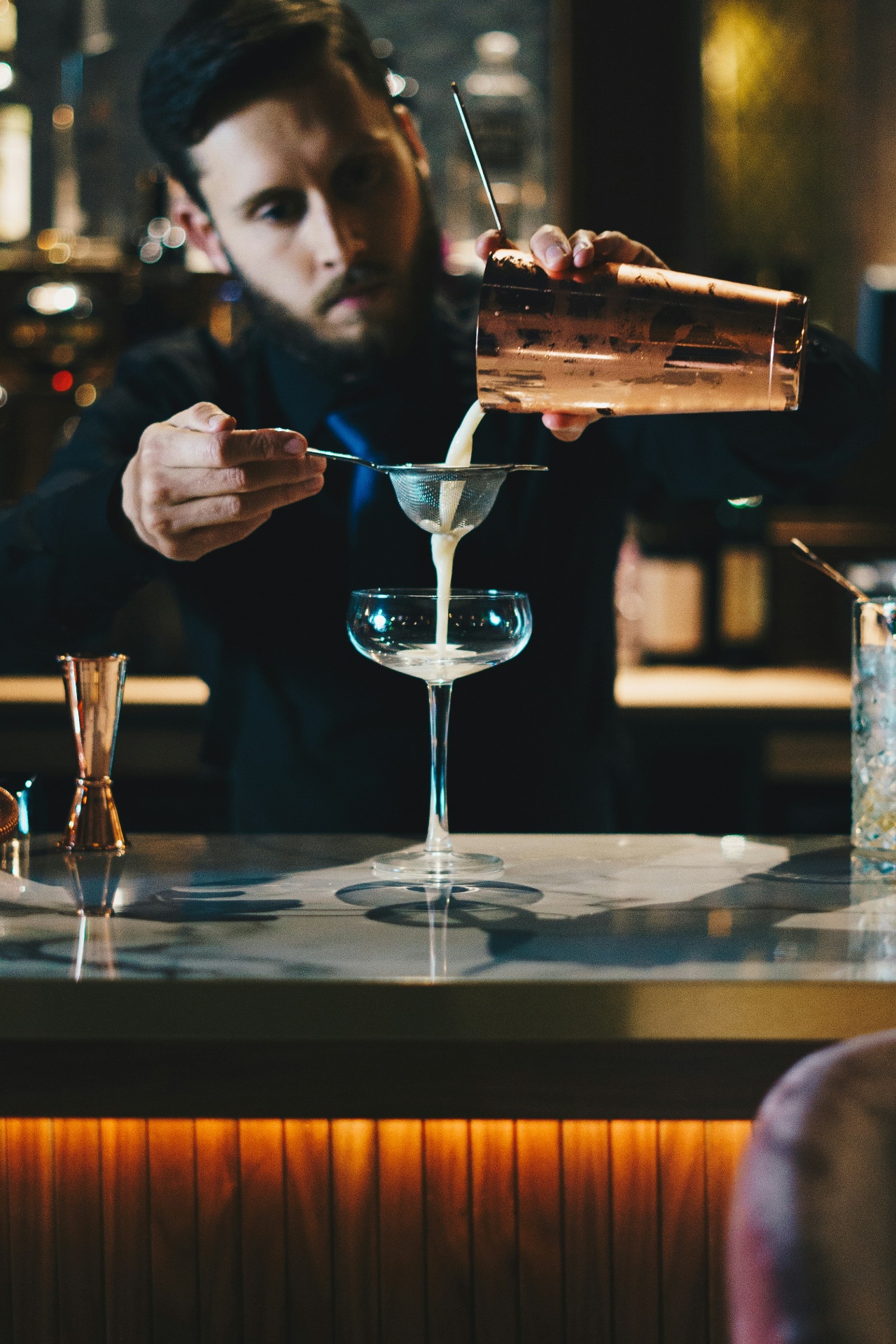 Bartender som gör i ordning en drink bakom baren
